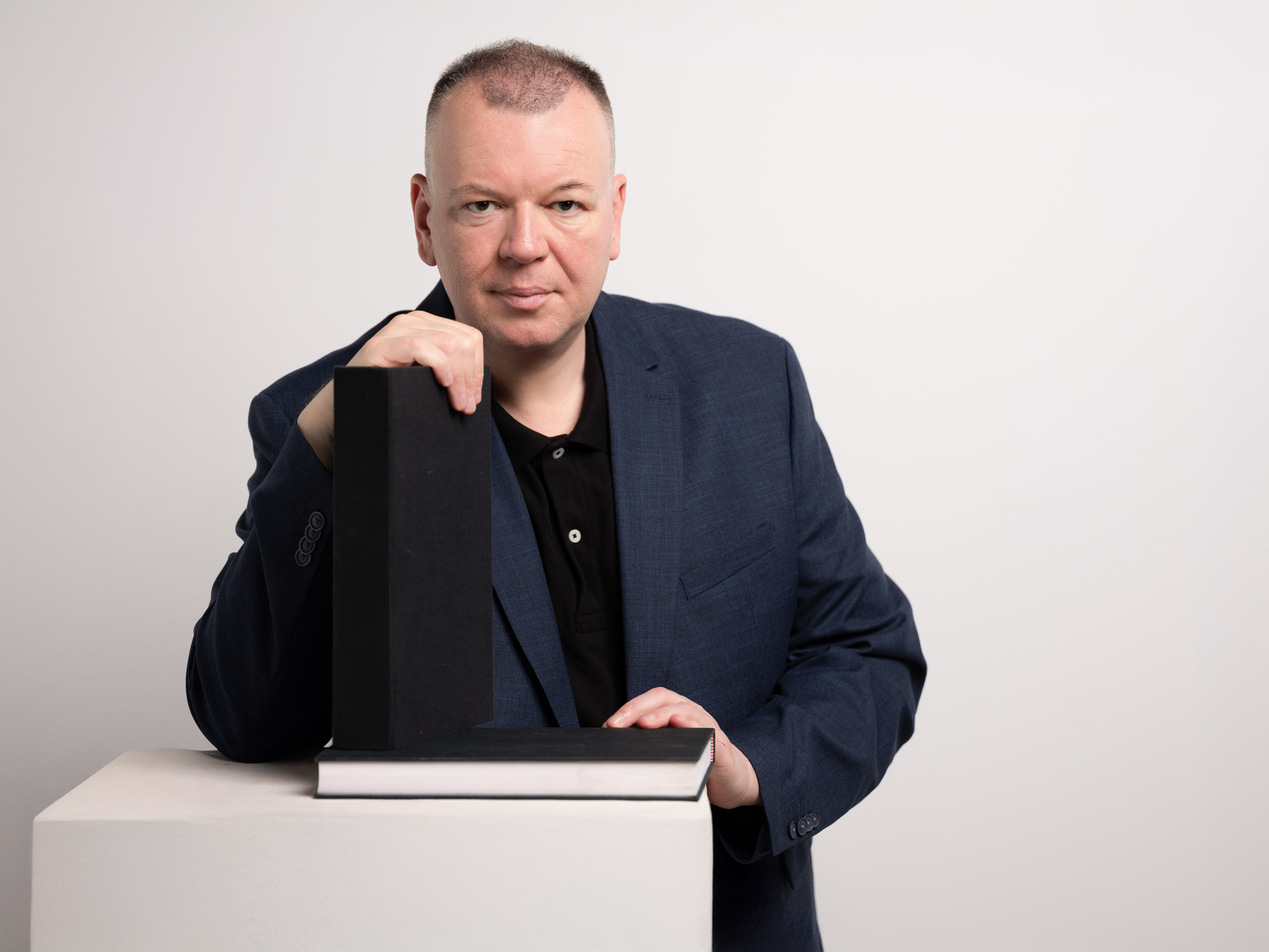 vergrößern Stefan Weber mit zwei Büchern